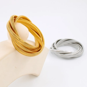 Dettaglio di bracciali a serpente a quattro strati in oro e argento su base minimale