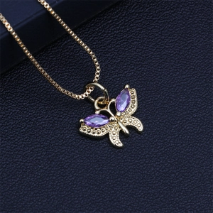 Macro view of gold butterfly pendant featuring marquise-cut purple crystals on chain