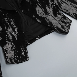 Vue détaillée des paillettes argentées sur un blazer noir avec une doublure de qualité