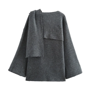 Dettaglio del cappotto in maglia grigio scuro con collo sciarpa e maniche ampie