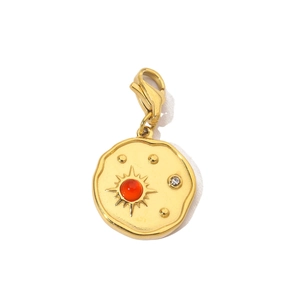 Detail of vintage sunburst pendant with red stone and white zircon on gold finish