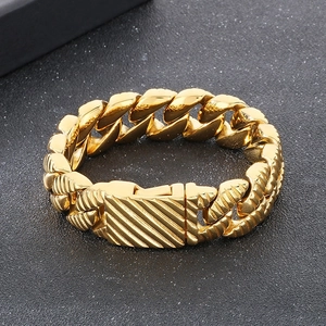 Macro detail of gold-plated thick Cuban link bracelet with striped square clasp