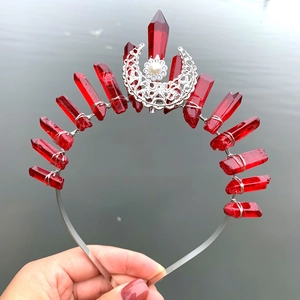 Detailed view of handmade silver crown with red crystal stones and white pearl moon charm