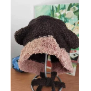 Dettaglio cappello pescatore in peluche con bordo a contrasto e lacci imbottiti