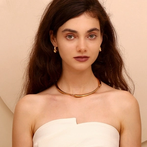 Detail showing the hammered 18K gold-plated torque necklace and matching hook earrings