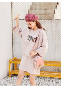 Dettaglio di un set casual in maglia con felpa stampa cartoon e minigonna abbinata