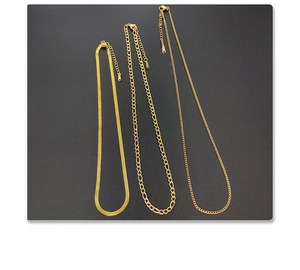Close-up of three 18k gold plated titanium steel chains including Figaro and snake styles