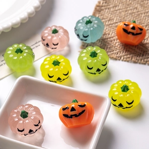 Detailed view of colorful resin Halloween pumpkin charms with carved smiling faces