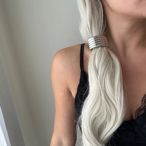 Detail of silver alloy multi-loop hair ring securing a ponytail for a sleek, modern look