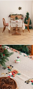 Detailed view of beige Christmas tablecloth with festive embroidery and woven texture