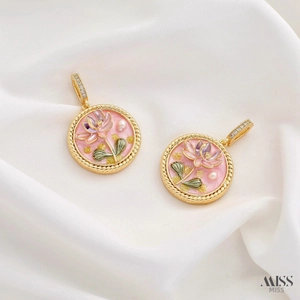 Detail of gold floral enamel pendants with pink lotus and pearls on white silk