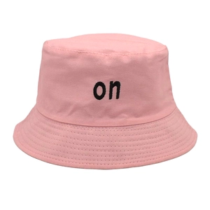 Detail of pink cotton bucket hat featuring black embroidered on text and stitched brim