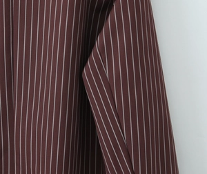 Macro detail of the wine red fabric with white pinstripes showing texture and drape