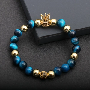 Close-up of blue tiger eye beaded bracelet with a black diamond gold crown charm