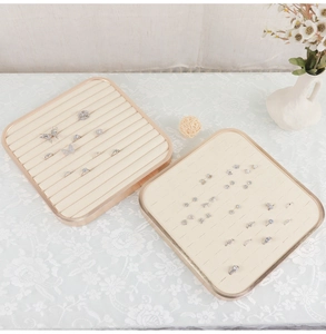 Detail view of cream jewelry display trays for rings and earrings on lace fabric
