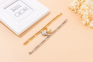 Detailed shot of gold and silver heart pendant bracelets with thick link chains