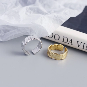 Close-up of irregular foil texture on S925 sterling silver rings in gold and silver