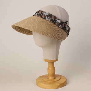 Detail view of woven straw sun visor with delicate white rose floral embroidery