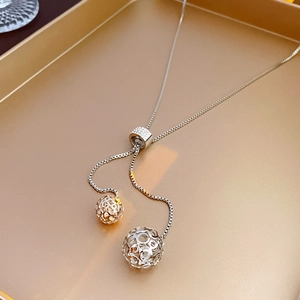 Détail du collier réglable en acier titane argenté avec pendentifs sphériques évidés