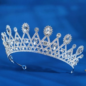 Macro detail of silver bridal tiara with sparkling rhinestones on deep blue background