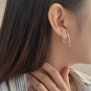 Close-up of minimalist S925 silver earrings with geometric circle and bar design