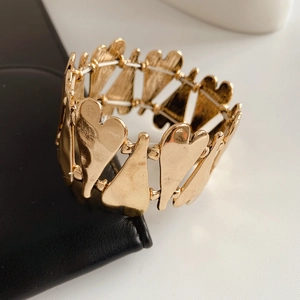Gros plan sur un bracelet extensible à cœurs dorés métalliques avec fini poli