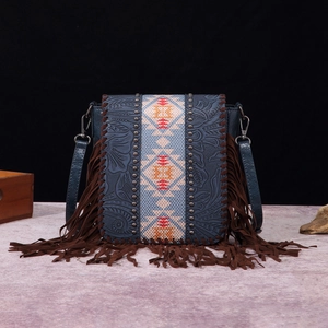 Detail of bohemian embossed leather crossbody bag with vintage floral patterns and fringe
