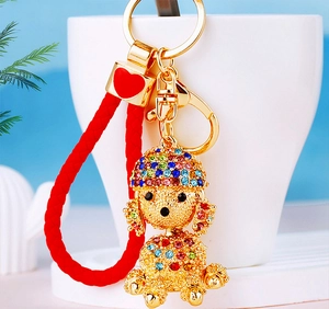 Detailed shot of golden poodle keychain with colorful rhinestones and red woven strap
