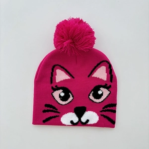 Detail of hot pink knitted hat featuring a cartoon cat face and large fluffy pom-pom