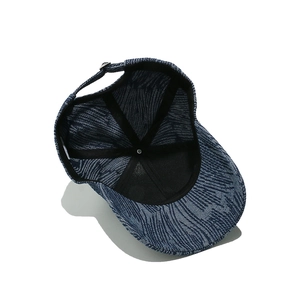 Detail view of denim baseball cap interior with stitching and adjustable metal buckle