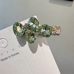 Détail d'une barrette coréenne avec cristaux vert olive et strass argentés étincelants
