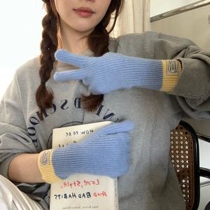 Detail of color-block knit gloves in blue and yellow with tactile touchscreen fingertips
