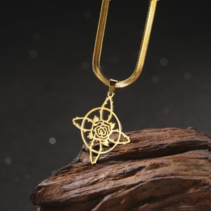 Gros plan d'un collier chaîne serpent dorée avec pendentif rose évidée