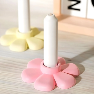 Gros plan de bougeoirs en forme de fleur en silicone aux tons pastel rose et jaune