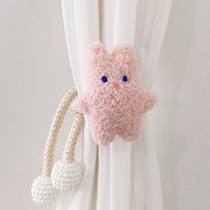 Detail view of pink plush bunny curtain tieback with woven rope and pearl fasteners