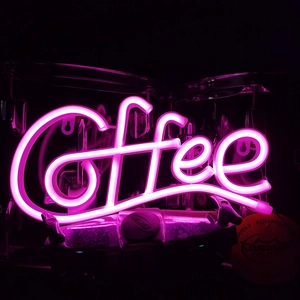 Close-up of a pink LED neon Coffee sign with flexible tubes glowing in a dark setting