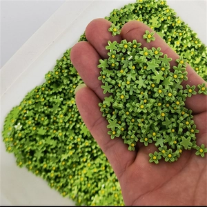 Detail shot of green resin five-petal flowers with yellow centers for 3D nail art decoration