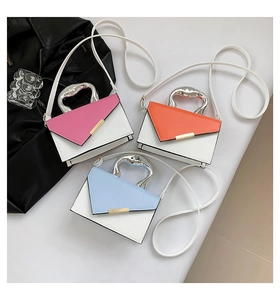 Detail of color block crossbody bag featuring unique silver liquid metal handle and gold clasp