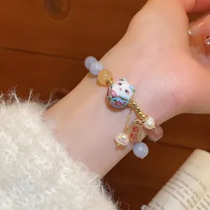 Handmade lucky cat pearl bracelet with colorful beads and gold charm on female wrist