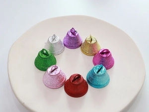 Close-up of colorful 26mm glittery metal bells for Christmas decor and DIY crafts