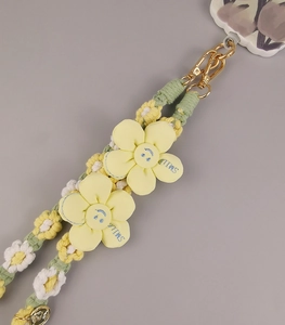 Detail of hand-woven daisy phone lanyard with yellow smile flowers and gold metal clips