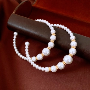 Detail eines eleganten Perlenstirnbands mit Verlaufsperlen und goldenen Akzenten