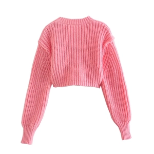 Dettaglio del maglione corto rosa a costine con trama morbida e design a girocollo