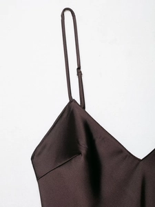 Gros plan d'une robe en satin marron avec décolleté en V et fines bretelles réglables