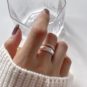 Macro shot of 925 sterling silver ring with irregular hammered texture on model finger
