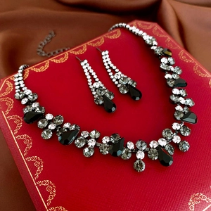 Detail of crystal teardrop necklace and earring set inside a luxury red gift box