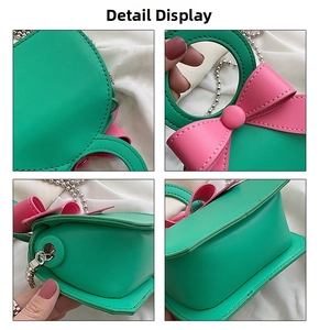 Detail view of mini green PU handbag showing pink bow, metal chain, and stitching