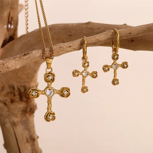 Detail of 18K gold plated cross necklace and earrings with white gems on branches
