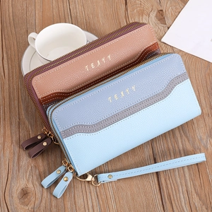 Macro shot of stylish dual-zipper wallets with litchi texture and gold hardware detailing