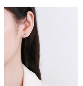 Close-up of a silver tulip bud stud earring with a marquise-cut crystal on an ear